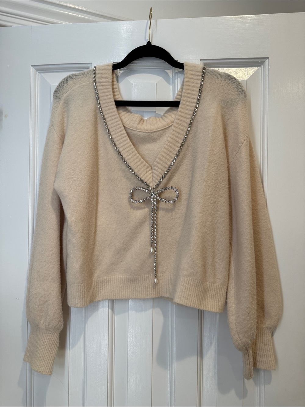Cream V-Neck Sweater with Rhinestone Bow Detail can be worn off the shoulder med